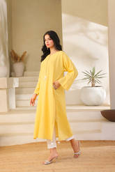 First utter yellow self cotton kurta by Zananii featuring pearl buttons and handmade tassels, paired with white slub viscose pants for a graceful and effortless everyday look.