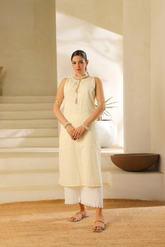 Sleeveless cream cotton chikankari kurta with tassel accents, paired with white slub viscose pants from Zananii’s Laaj Collection.