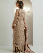 Model in nude beige embroidered outfit with chandelier and wall sconce lighting