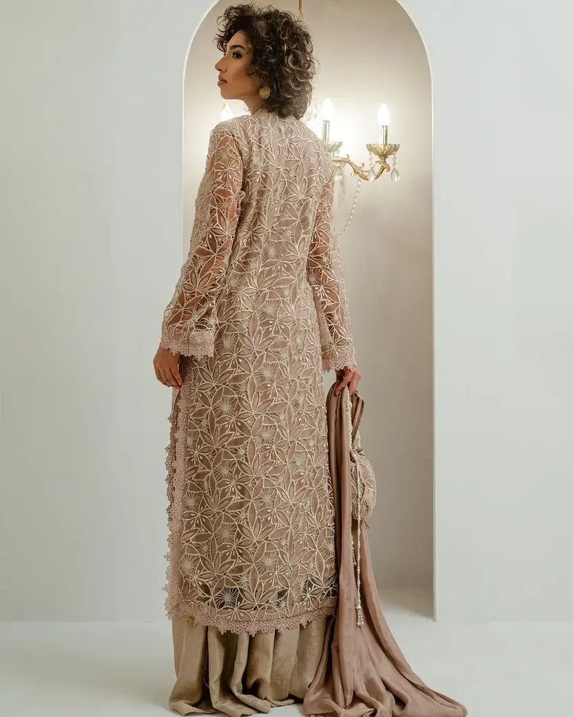 Model in nude beige embroidered outfit with chandelier and wall sconce lighting